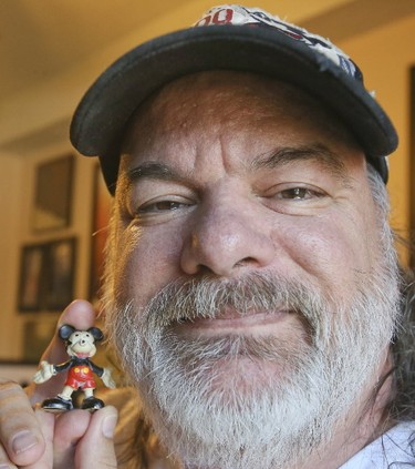 Paul Bottos holds the very first piece of his collection. He now owns close to 10,000 Mickey Mouse items and keeps them in the basement of his Hamilton home on on July 25, 2017. (Veronica Henri/Toronto Sun)