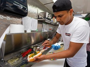 Abhijeet Chougule makes Montreal Steamies at the Montreal Hotdogs food truck at K-Days, in Edmonton Saturday July 29, 2017. Photo by David Bloom