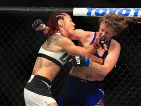 Cris Cyborg (left) lands a punch on Tonya Evinger during their featherweight title fight at UFC 214 in Anaheim last night. The match was stopped in the third round. Getty Images)