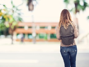 In this stock photo, a female student walks alone on a university campus. (Getty Images)