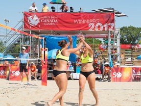 Kearley Abbott (left) congratulates her twin sister Josie as the Manitoba duo won their opening match in beach volleyball at the Canada Summer Games in Winnipeg on Sunday, July 30, 2017, after a 2-0 victory over New Brunswick. JESSICA ALCANTARA/Team Manitoba