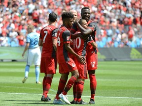 Toronto FC’s Sebastian Giovinco (10) celebrates with teammates including Jozy Altidore (right) during yesterday’s win. (THE CANADIAN PRESS)