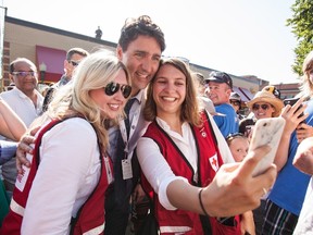 Prime Minister Justin Trudeau poses for a selfie with Canadian Red Cross workers at event stop in Revelstoke, B.C., on Saturday July 29, 2017. THE CANADIAN PRESS/Jeff Bassett