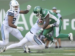 Roughriders running back Greg Morris gets stopped in his tracks by an Argonaut in Regina on Saturday. (The Canadian Press)
