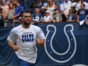 Indy Colts quarterback Andrew Luck runs to the locker room after signing autographs on the first day of camp Sunday at Lucas Oil Stadium. (JOHN KRYK/Postmedia Network)