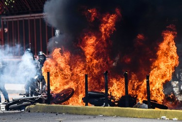 Two police motorbikes burn in flames after an explosive devise exploded as they drove past during a protest against the elections for a Constituent Assembly in Caracas on July 30, 2017. JUAN BARRETO/Getty Images
