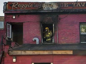 A Sault Ste. Marie Fire Services firefighter inspects fire-damaged rooms above Reggie's Place Tavern Sunday evening. BAMBANG SADEWO/SPECIAL TO THE STAR