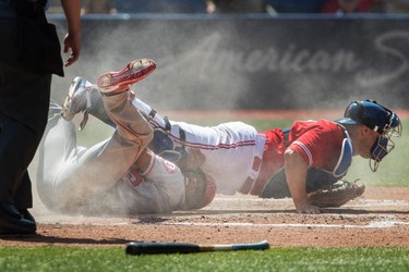 Los Angeles Angels Ben Revere slides through the legs of Toronto Blue Jays catcher Miguel Montero to score on a sacrifice fly in the fifth inning of their AL baseball game in Toronto on Sunday, July 30, 2017. THE CANADIAN PRESS/Fred Thornhill ORG XMIT: FJT09
