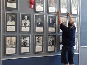 A worker adjusts Belleville Sports Hall of Fame plaques being relocated to the Dr. Robert L. Vaughan Atrium at the east end (second floor) of the Sports Centre in anticipation of Sept. 16 Class of 2017 induction ceremonies. (Submitted photo)