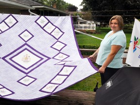 It took 44 years, but Mitchell’s Gladys Brosens (back) recently completed this king size Canada quilt – during the country’s Sesquicentennial year. She needed help from friend Wanda Quiriple (right) and her daughters Sydney (left) and Savannah, of Stratford, to display it. ANDY BADER/MITCHELL ADVOCATE