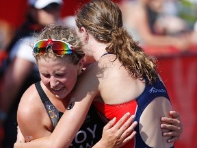 Manitoba's Kyla Roy collapses into the arms of British Columbia's Desirae Ridenour as she crosses the line to come in third behind Ridenour in the Canada Summer Games Female Individual Triathalon at Birds Hill Park just outside Winnipeg, Man. on Monday, July 31, 2017. THE CANADIAN PRESS/John Woods