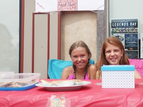 From the left, Bailey Stackhouse, 11, and Morgan Marks, 11 from Seaforth set up a lemonade stand and sold baked goods on Main Street last Friday. All the funds were donated to the Seaforth and District Foodbank. (Shaun Gregory/Huron Expositor)