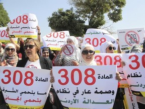 Women activists protest in front of Jordan's parliament in Amman on Tuesday, August 1, 2017 with banners calling on legislators to repeal a provision that allows a rapist to escape punishment if he marries his victim. (Reem Saad/AP Photo)