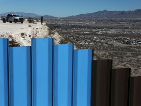 In this Jan. 25, 2017, file photo, an agent of the border patrol, observes near the Mexico-US border fence, on the Mexican side, separating the towns of Anapra, Mexico and Sunland Park, N.M. (AP Photo/Christian Torres, File)