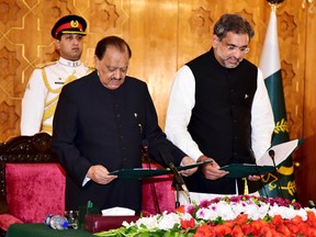 In this photo released by Pakistan's Press Information Department, newly-elected Prime Minister of Pakistan Shahid Khaqan Abbasi, takes oath from Pakistani President Mamnoon Hussain at the Presidential palace in Islamabad, Pakistan, Tuesday, Aug. 1, 2017. (Pakistan Press Information Department, via AP)