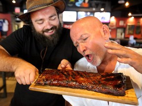 Victor Anast of Kentucky Smokehouse offers up the ultimate temptation to London Ribfest president Doug Hillier. Hillier hasn?t eaten meat since January 6th as part of a challenge, but plans to start again with ribs on Thursday. In those months of vegetarianism, Hillier lost 40 pounds and dropped six inches on his waistline. (MIKE HENSEN, The London Free Press)