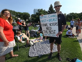 Michael Elves holds a sign during a rally and picnic protesting cuts to the Lactation Consultant program at Health Sciences Centre held at the Manitoba Legislative Building grounds in Winnipeg on Tues., Aug. 1, 2017. Kevin King/Winnipeg Sun/Postmedia Network
