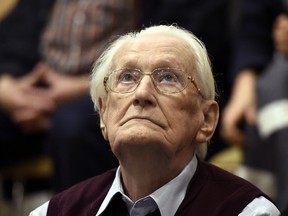 In this July 15, 2015 file photo 94-year-old former SS sergeant Oskar Groening looks up as he listens to the verdict of his trial at a court in Lueneburg, northern Germany. German prosecutors said Wednesday, Aug. 2, 2017 they consider the 96-year-old former Auschwitz death camp guard who was convicted of being an accessory to murder fit to go to prison. Oskar Groening was convicted in July 2015 of being an accessory to the murder of 300,000 Jews and sentenced by a court in Lueneburg to four years in prison. (Tobias Schwarz/Pool Photo via AP,file)