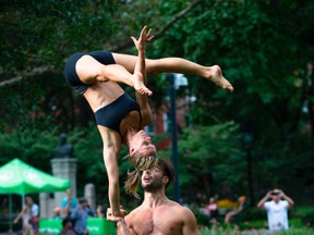 This undated photo provided by Peter Cooper shows Mike Aidala and Chelsey Khorus working on a skill called a Figa in New York's Washington Square Park. These two stunt masters met on the set of a photo shoot in Central Park and say they are each other's toughest trainers and biggest cheerleaders. It's tempting to blow off a workout, but getting sweaty with your significant other makes a workout more fun and ups the intensity ante. (Peter Cooper via AP)
