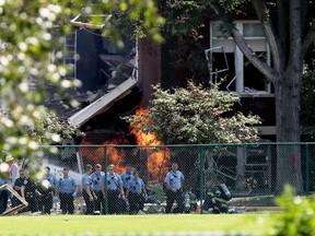 Emergency personnel move away as a gas fire continues to burn following an explosion at Minnehaha Academy Wednesday, Aug. 2, 2017, in Minneapolis. Several people are unaccounted for after an explosion and partial building collapse Wednesday at a Minneapolis school, fire officials said. (David Joles/Star Tribune via AP)