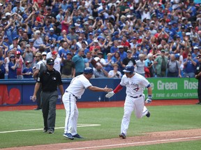 Steve Pearce of the Toronto Blue Jays is congratulated as he rounds the bases after hitting a game-winning grand slam home run against the Oakland Athletics at Rogers Centre on July 27, 2017. (Tom Szczerbowski/Getty Images)