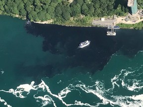 In this July 29, 2017 photo provided by Rainbow Air INC., black-coloured wastewater treatment discharge is released into water below Niagara Falls, in Niagara Falls, N.Y. (Patrick J. Proctor/Rainbow Air INC. via AP)