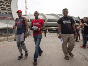 Asylum seekers from Haiti leave Olympic Stadium Thursday, August 3, 2017 in Montreal.The stadium is being used as temporary housing to deal with the influx of asylum seekers arriving from the United States. (THE CANADIAN PRESS/Ryan Remiorz)