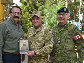 Presenting Col. Igor Slisarchuk with a copy of “A Canadian Hero” at IPSC, Yavoriv, Ukraine, on July 15. Lt.-Gen. Paul Wynnyk is at right.