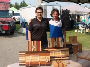 Graham Flaig, left and Liam Barrell from Airdrie Woodworks show off their work at the Airdrie Farmers Market on July 19, 2017. The teenagers started up their company last fall and are found at local farmers markets.