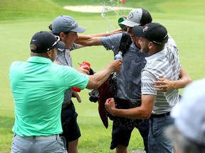 Calvin Ross, second from right, of Fredericton, New Brunswick gets a water shower from friends at the Cataraqui Golf and Country Club in Kingston on Thursday after winning the Canadian Junior Boys Golf Championship. (Ian MacAlpine/The Whig-Standard)