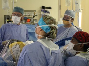 Supplied photo    
Dr. Grace Ma (top right) and Dr. Antonio Caycedo (bottom right) perform colorectal cancer surgery at Health Sciences North. Assisting are registered nurse Sylvie Greenhalgh, (centre), and Dr. Raymond Gay (far left).