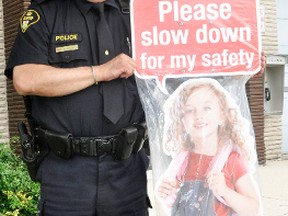 West Perth OPP Sgt. Manny Coelho stands with “Sally” a four-foot aluminum sign that will be used to remind drivers to slow down. This sign, which can be used in the community by contacting the OPP, and radar speed signs downtown are tools the Police Services Board and the OPP will utilize in an attempt to slow down speeding drivers. ANDY BADER/MITCHELL ADVOCATE