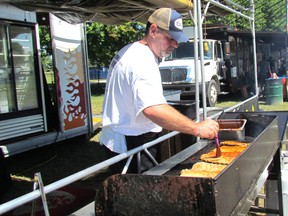 Terry Slowka, with Smokin' Joes, brushes sauce on ribs Friday June 7, 2017 on the opening day of the Sarnia Kinsmen Ribfest's return to Centennial Park in Sarnia. This is the 17th year for the Kinsmen fundraiser and crews were hard at work Friday morning cleaning up from a storm that blew through Thursday night, knocking down tents and soaking the ground. (Paul Morden/Sarnia Observer/Postmedia Network)