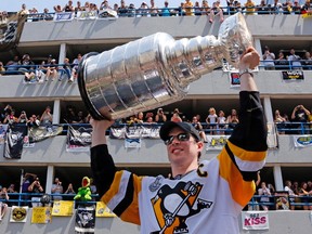 Pittsburgh Penguins' Sidney Crosby hoists the Stanley Cup during the team's Stanley Cup NHL hockey victory parade on Wednesday, June 14, 2017, in Pittsburgh. (THE CANADIAN PRESS/AP-Gene J. Puskar)