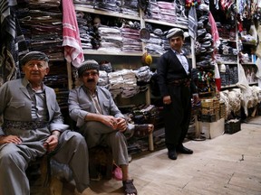 Iraqi Kurdish men sit outside a shop near the citadel and the City Park in Arbil, the capital of the autonomous Kurdish region of northern Iraq, on July 23, 2017. / AFP PHOTO / SAFIN HAMEDSAFIN HAMED/AFP/Getty Images
