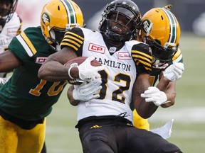 Hamilton Tiger-Cats' C.J. Gable (32) is tackled by Edmonton Eskimos Christophe Mulumba-Tshimanga (10) and D'Anthony Batiste (64) during first half CFL action in Edmonton, Alta., on Friday August 4, 2017.