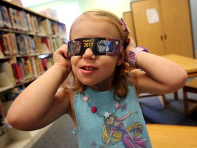 In this Wednesday, Aug. 2, 2017 file photo, Emmalyn Johnson, 3, tries on her free pair of eclipse glasses at Mauney Memorial Library in Kings Mountain, N.C. Glasses are being given away at the library for free while supplies last ahead of the big event on Aug. 21. (Brittany Randolph/The Star via AP)