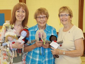 Linda Woods, Laurel Kelley and Sarnia's Ann Carr hold up several Dolls of Hope during a workshop at Dunlop United Church. The dolls will be given to the 338 MPs in Ottawa on Nov. 21 as part of the United Church's Bread Not Stones campaign to end child poverty. Carl Hnatyshyn/Postmedia Network