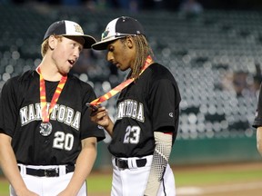 Team Manitoba players examine their silver medals in baseball at the 2017 Canada Summer Games at Shaw Park in Winnipeg, Man., on Friday, August 4, 2017. (Brook Jones/Postmedia Network)