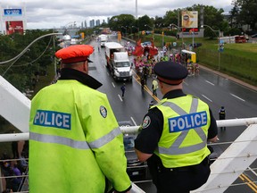 Two Toronto cops watch the start of the Toronto Carnival parade at the CNE on Saturday August 5, 2017. Michael Peake/Toronto Sun/Postmedia Network