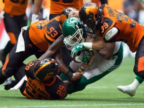 Saskatchewan Roughriders’ Nic Demski, centre, is tackled by B.C. Lions’ Steven Clarke (29), Jordan Herdman (53) and Chandler Fenner (39) in Vancouver, B.C., on Saturday August 5, 2017. (THE CANADIAN PRESS/Darryl Dyck)