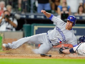 Rob Refsnyder of the Toronto Blue Jays avoids the tag of Brian McCann of the Houston Astros as he scores in the tenth inning at Minute Maid Park on August 5, 2017 in Houston. (Bob Levey/Getty Images)