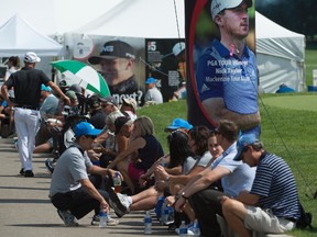 Volunteers, caddies and players wait out a weather delay outside the clubhouse. Lightning in the area forced the delay of the third round of the Syncrude Oil Country Golf Championship at the Windermere Gold Club on August 5, 2017.