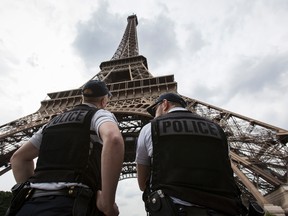 In this Friday, June 10, 2016 file photo, French riot police officers patrol under the Eiffel Tower, in Paris. A young French man who recently was discharged from a psychiatric hospital is under investigation for glorifying terrorism after he brandished a knife and tried to breach security at the Eiffel Tower, authorities said Sunday, Aug. 6, 2017. (AP Photo/Kamil Zihnioglu, File)