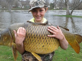 This April 22, 2017 photo released by John Stokes shows Stokes' son Chase, then 10, holding a giant carp, weighing 33.25 pounds, in Ferrisburgh, Vt. (John Stokes via AP)