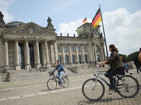 Visitors ride bicycles past the Reichstag, seat of the German parliament, the Bundestag, on July 13, 2015 in Berlin, Germany. (Photo by Sean Gallup/Getty Images)