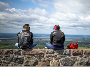 The mix of sun and clouds and cooler temperatures made for a perfect day to get out to Champlain Lookout in Gatineau Park Sunday August 6, 2017. Andrew Gaetano and Julie Beauchamp take a seat on the wall to check out the view.   Ashley Fraser/Postmedia