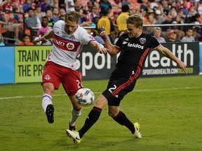 Toronto FC midfielder Nicolas Hasler shoots the ball past D.C. United defender Taylor Kemp during Saturday’s game. (AP)