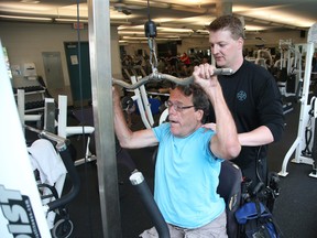 Trainer Ryan Armitage with John Woodhouse has dystonia and is a double leg amputee at the JCC in Ottawa.