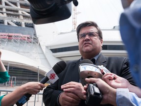 The Mayor of Montreal Denis Coderre speaks to the media as a bus of Haitian asylum seekers from the United States arrives at the Olympic Stadium in Montreal, Quebec on August 3, 2017. CATHERINE LEGAULT/Getty Images